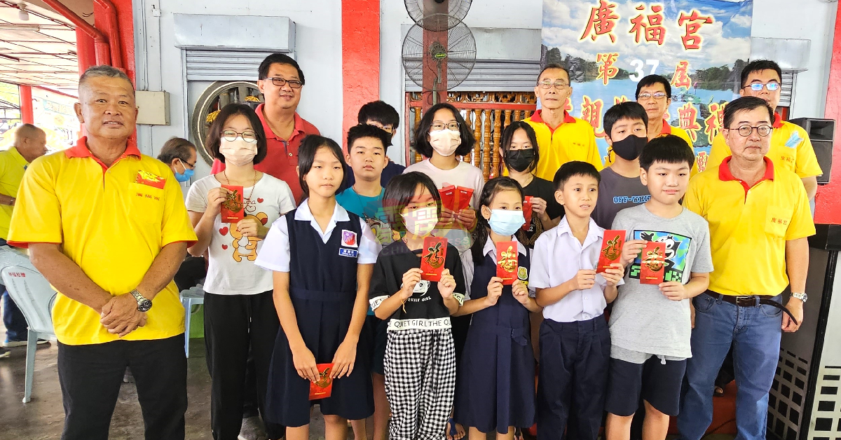 卢进发（前排左）和理事与领取奖励金的小学生分享喜悦。 