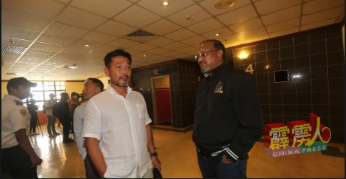 霹州足球俱乐部前任主教练林长金（左）与俱乐部总执行长波比（右），默然等待电梯准备离开工业关系局。
