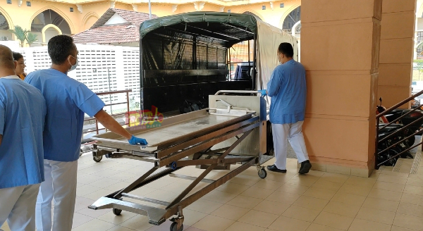 太平工作人员使用推车，把送抵太平间的遗体运入怡保太平间。