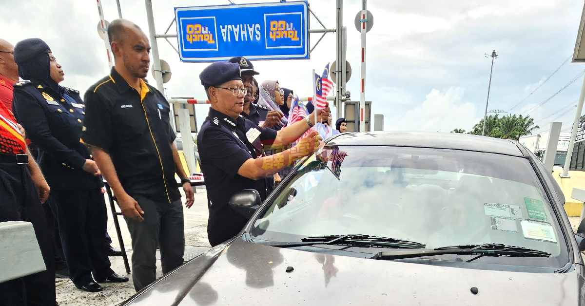 莫哈末诺丁（左3）为轿车安置小国旗。