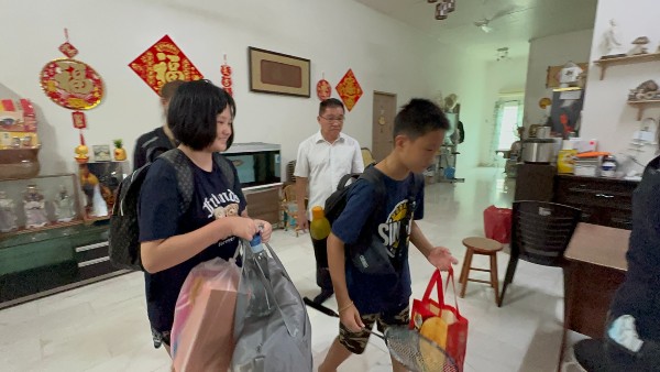 嘉晴（左起）与江嘉轩，收拾行李出发去孤儿院。