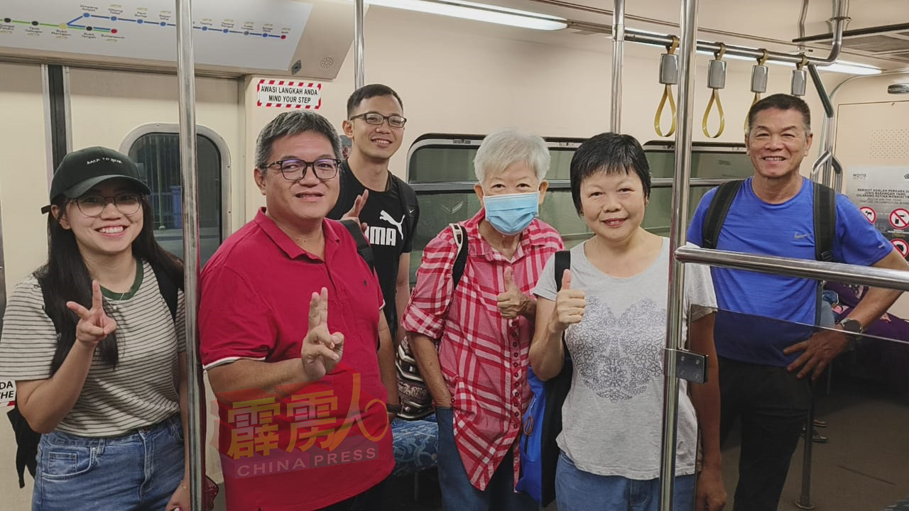 刘富宗（左2）与江锦娟（右2）及新旧同事相约乘搭电动火车到槟城一日游。