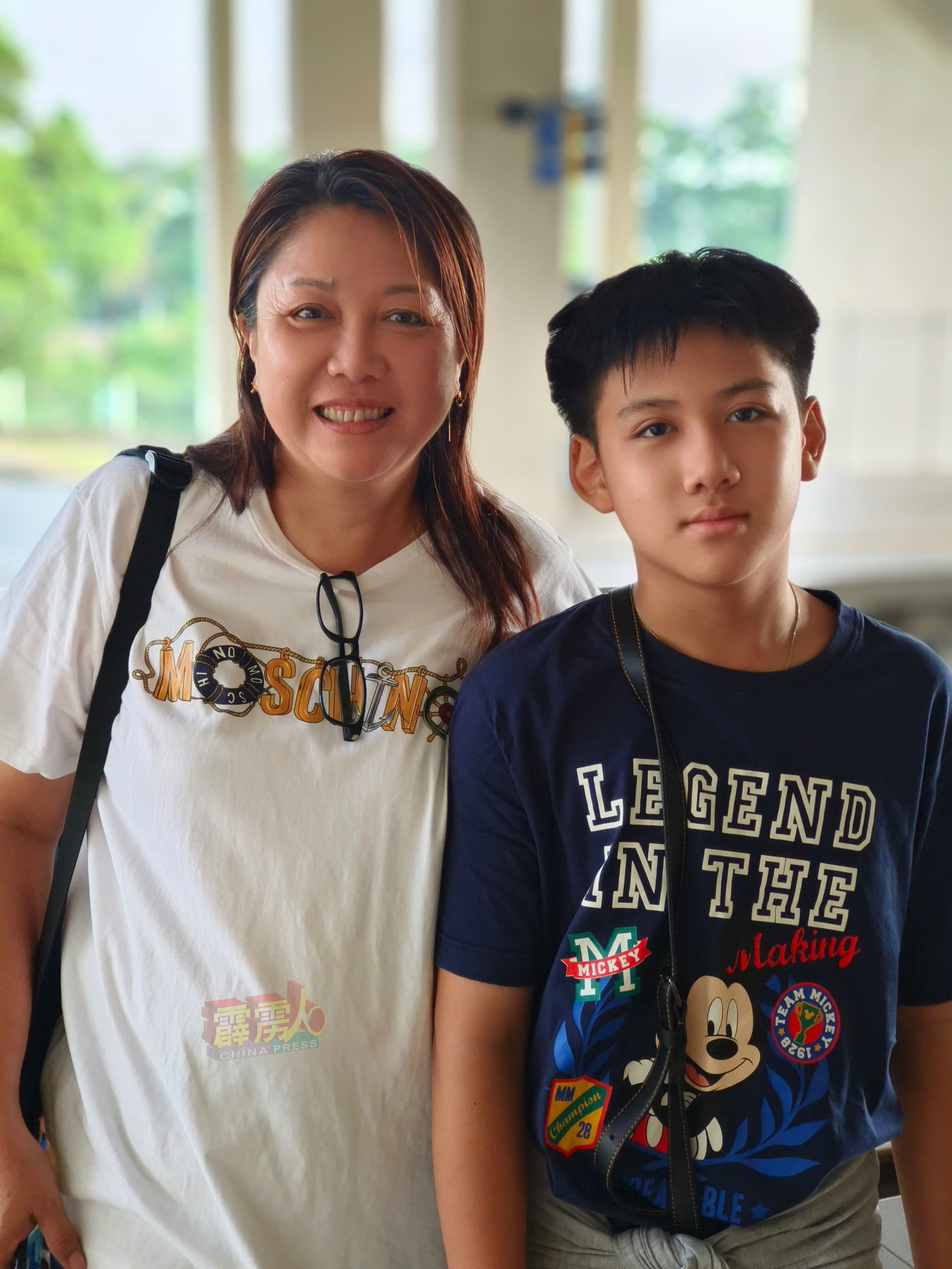 萧丽丽（左）带儿子搭电动火车到槟城半日游。

