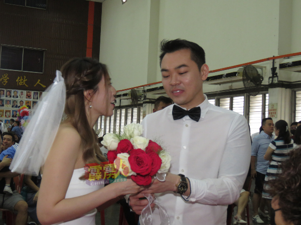 美发师冯伟杰 （右）注册结婚时，送花给雷佩婷（美发师）。
