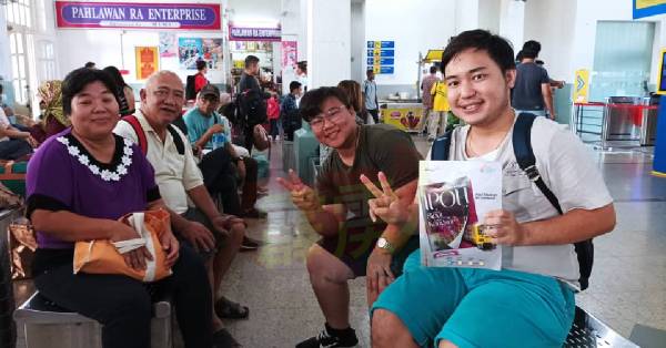 .陈康雄（右）获悉有单程免费车资，特带家人往北海一日游。
