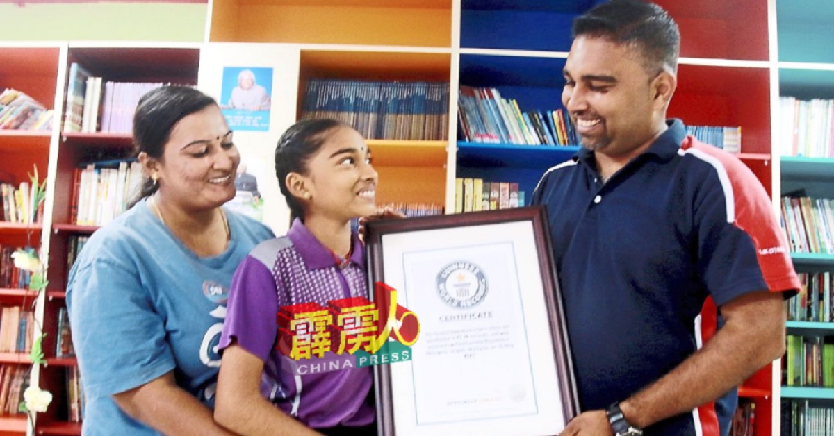 普尼塔马拉（中）与父母分享获颁健力士世界纪录证书的喜悦。左者为母亲西瓦桑卡丽；右者为父亲拉贾谢卡。 （自星报）