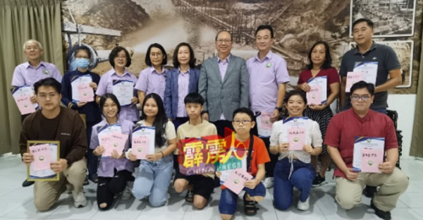 李志浩（站者右4起）、刘玉琼及刘玉美派发奖励金给考获优越成绩的会员子女。