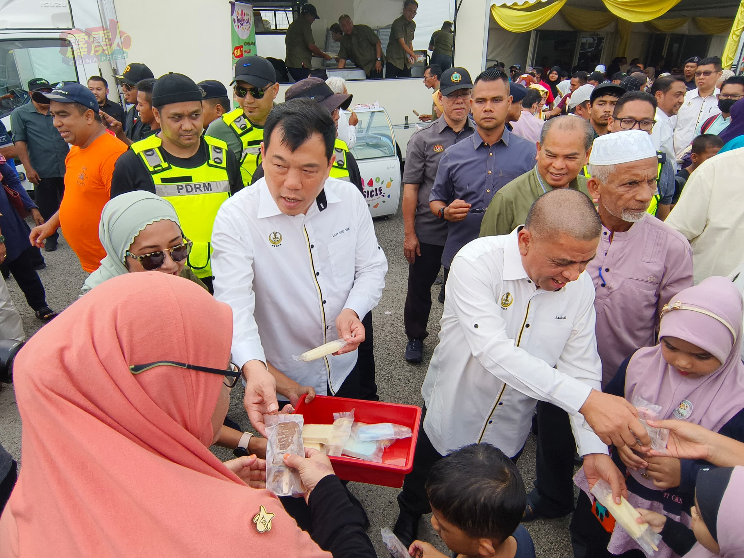 沙拉尼（右）为霹雳农业节闭幕后，联同州行政议员罗思议（左）分配冰淇淋给出席人士。