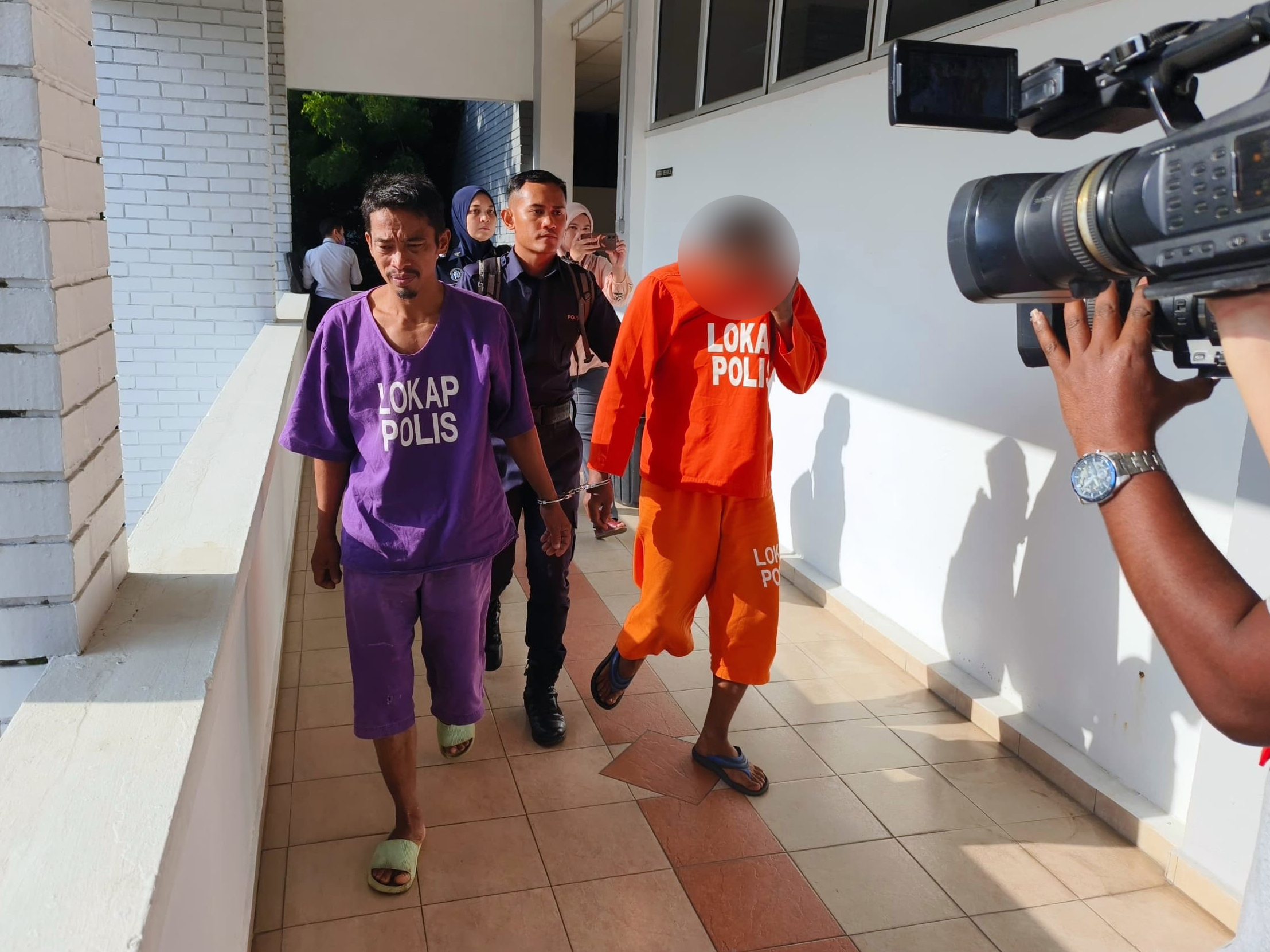 身穿橙色囚犯衣的强姦案被告，被庭警押往江沙地庭时，全程扯衣服遮面。