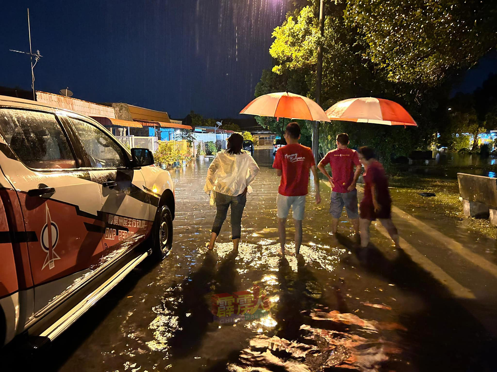吴家良的团队，在豪雨中撑伞到受水灾影响的住宅区巡视，了解原因。