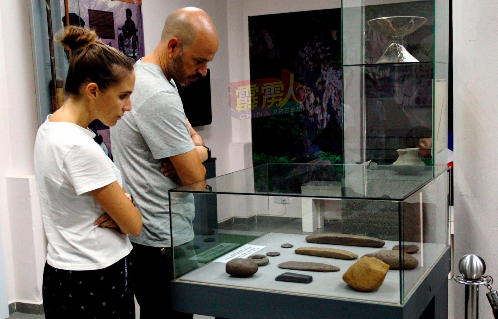 一对外国游客在玲珑考古珍藏馆观赏，玲珑谷发现石器时代的陶器和金属工具，证明了最早人类的存在。（马新社）