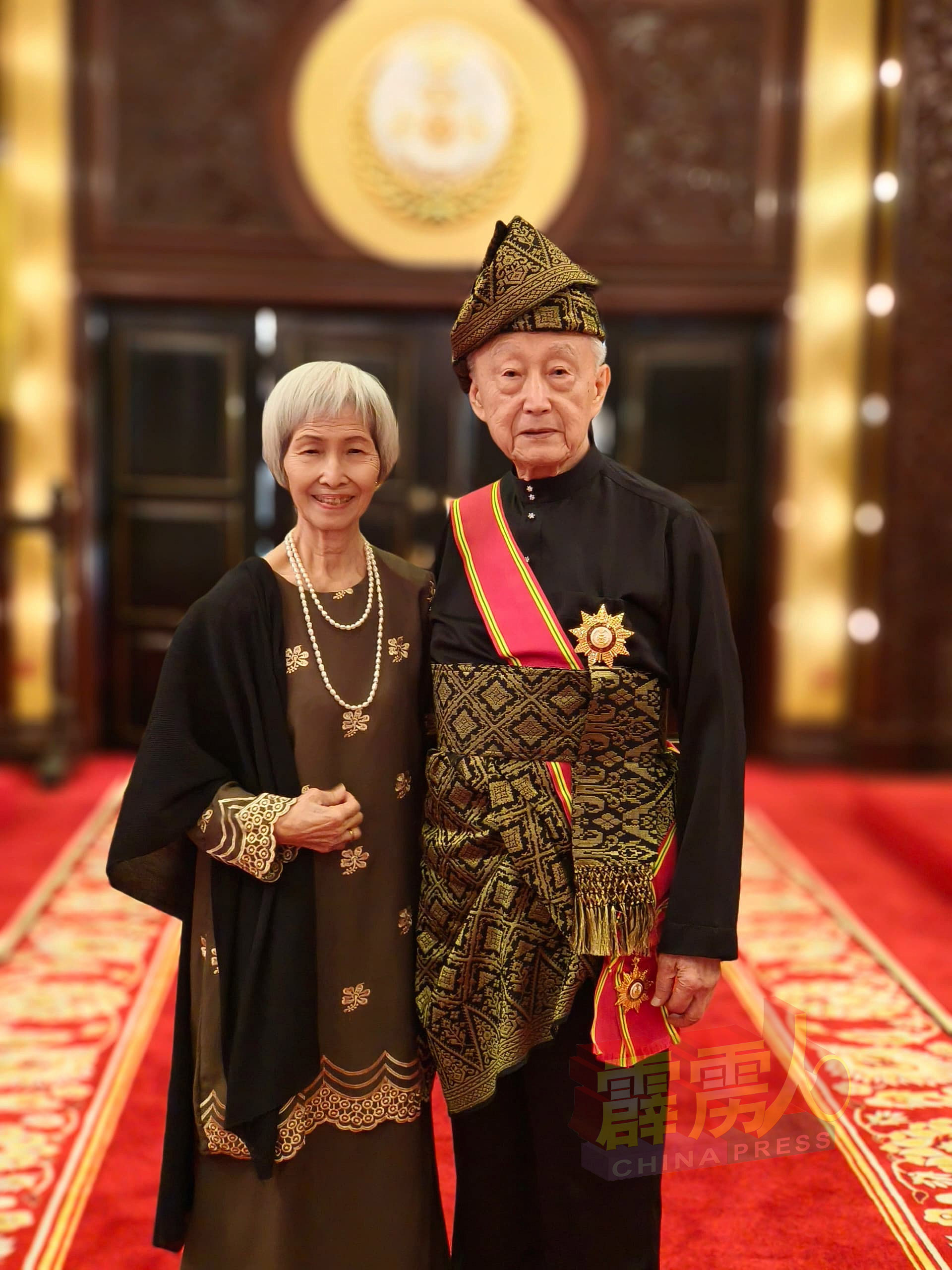 82岁的梁永宽（右）受封DPTS拿督，开心与太太陈玲旋在江沙王宫合影。