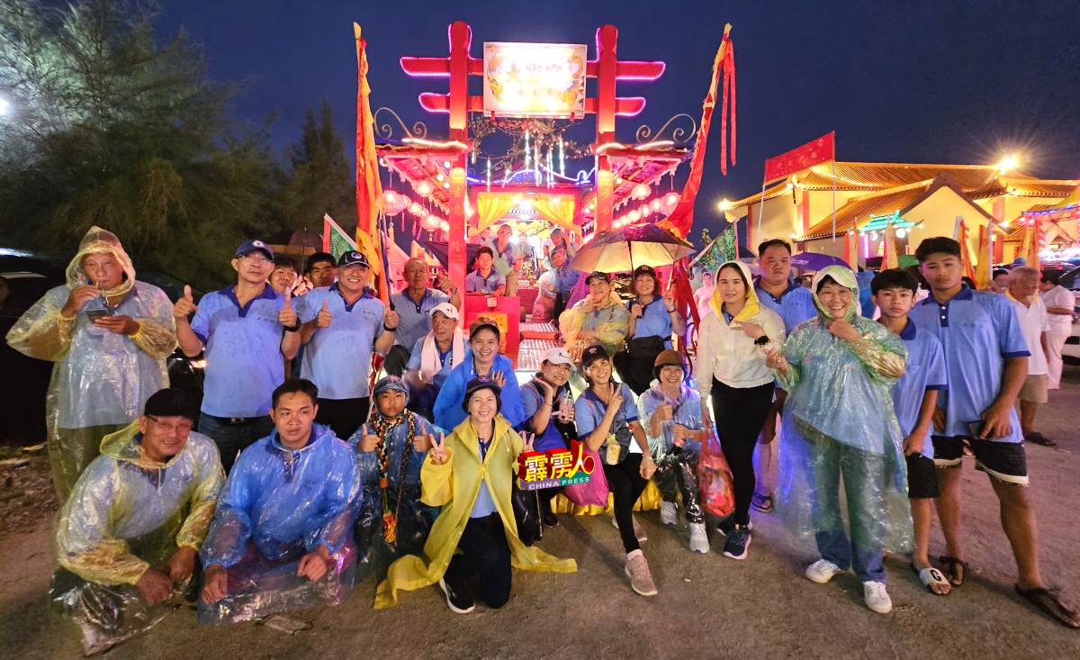 爱大华大灵宫游行团队自备雨具和雨衣，冒雨开心游行。