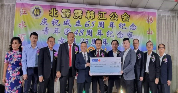 黄庆义(左5)移交5000令吉给太平华联独中董事部副财政郑天华;左起为李鸣凤、黄泉温、马良生、李来源、陈宝铭(左6起)及林克坚;右起为吴金东、李奕乔与李志坚。