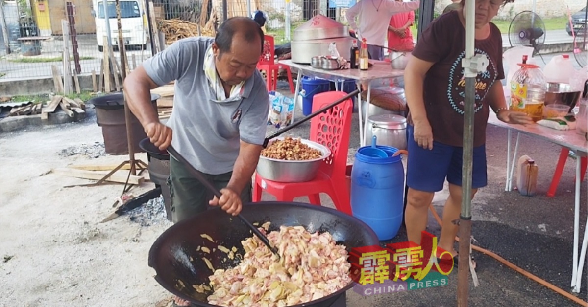 村民陈丽生（左）用长锅铲翻炒猪肉，掌握好火候和时间极其关键。