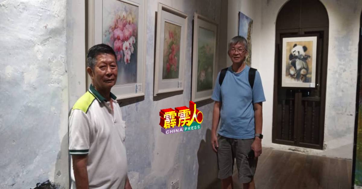 王景丰（左）与新国友好陈先生，一同观赏画作。