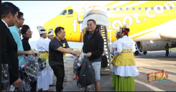 罗思义（左）赠送旅游年宣传礼袋给下机乘客。
