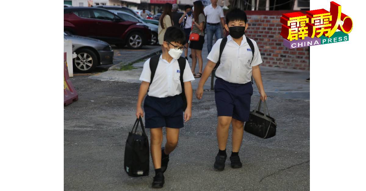 遵守教育部的指示和应对新冠肺炎近日暴增的病例，周二复课的学生们都佩戴口罩。