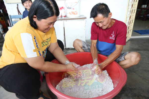 何玉梅（左）和丈夫洪玉兴，花近一个小时把糯米粉搓成浆。