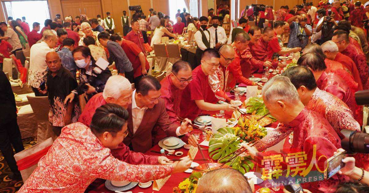 嘉賓身穿紅衣，並列長桌兩側，不分種族共同撈生喜洋洋。