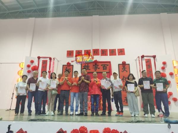 黄文标（右7）颁发奖状给巴占龙腾迎新春摄影比赛获胜者。左5起为罗国忠、黄涵威、黄国民和刘伟田。
