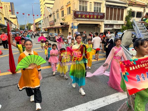 游行队伍穿上传统民族服装，百花齐放，彰显中华文化的特色。