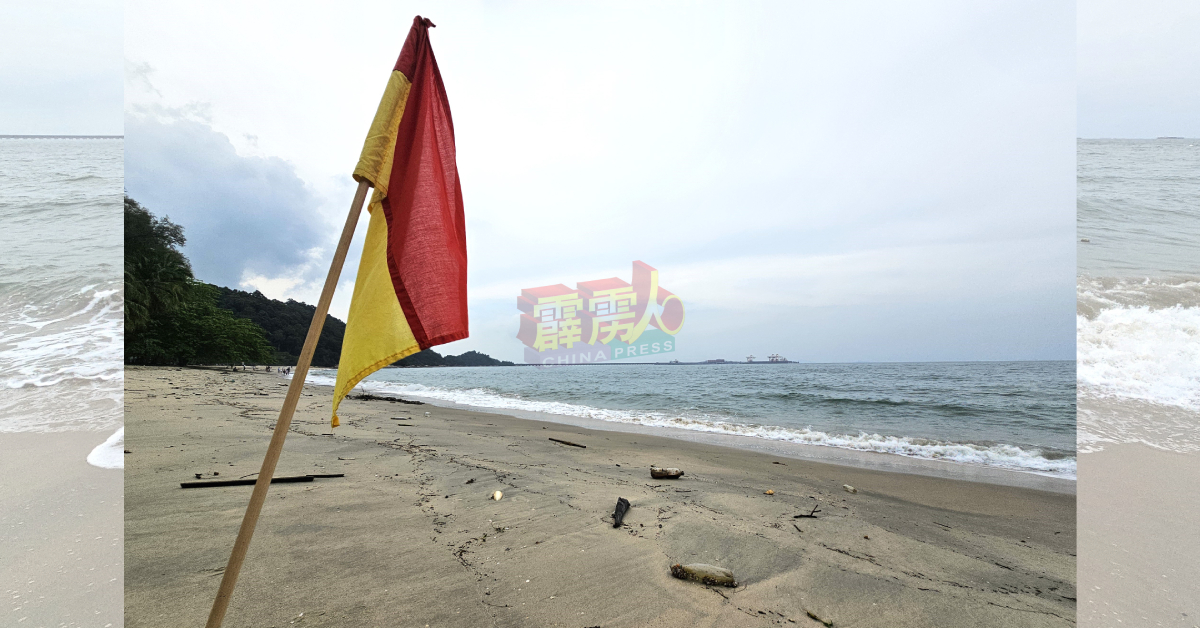 民防局驻直落峇迪眺望塔的救生员，每天都会依据海面情况，在沙滩处插上警惕旗帜。