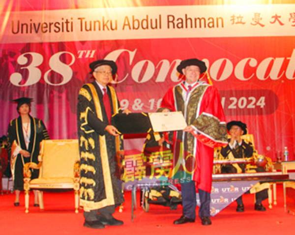 陈组排（右）代表拉曼大学颁发荣誉教授给张顺景高级院士。