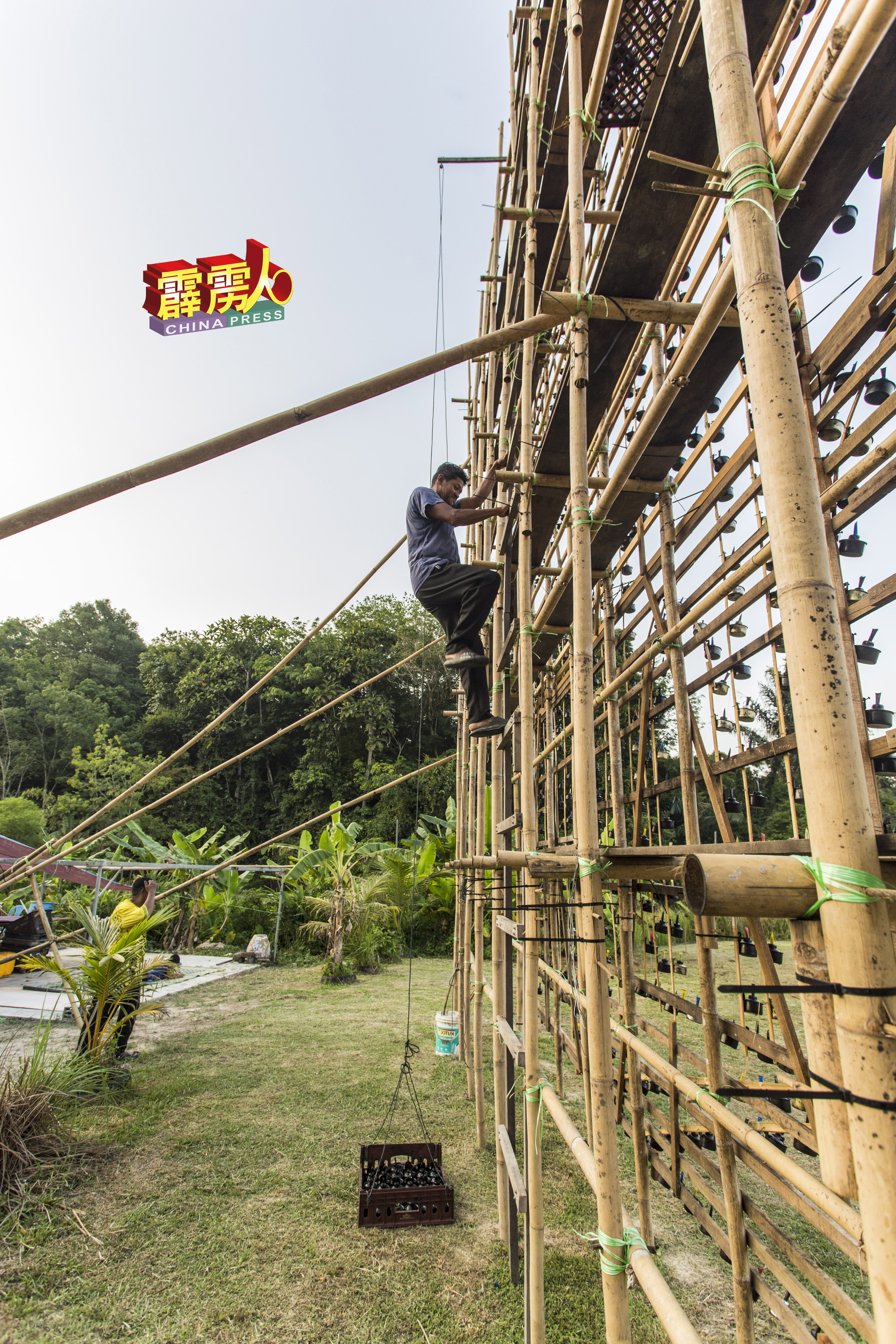 趁天黑入夜前，工作人员再次爬上竹棚架作最后一次的检查。