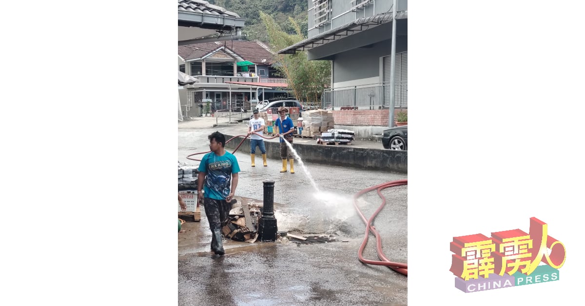 甘榜拉惹自愿防火委员会协助小贩及村民清洗泥泞工作。