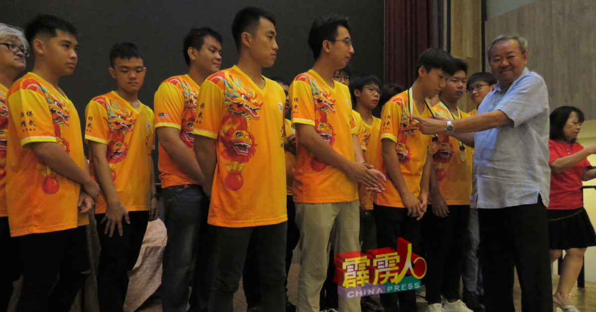 黄文辉（右）颁发奖牌给龙队队员。（精武提供）