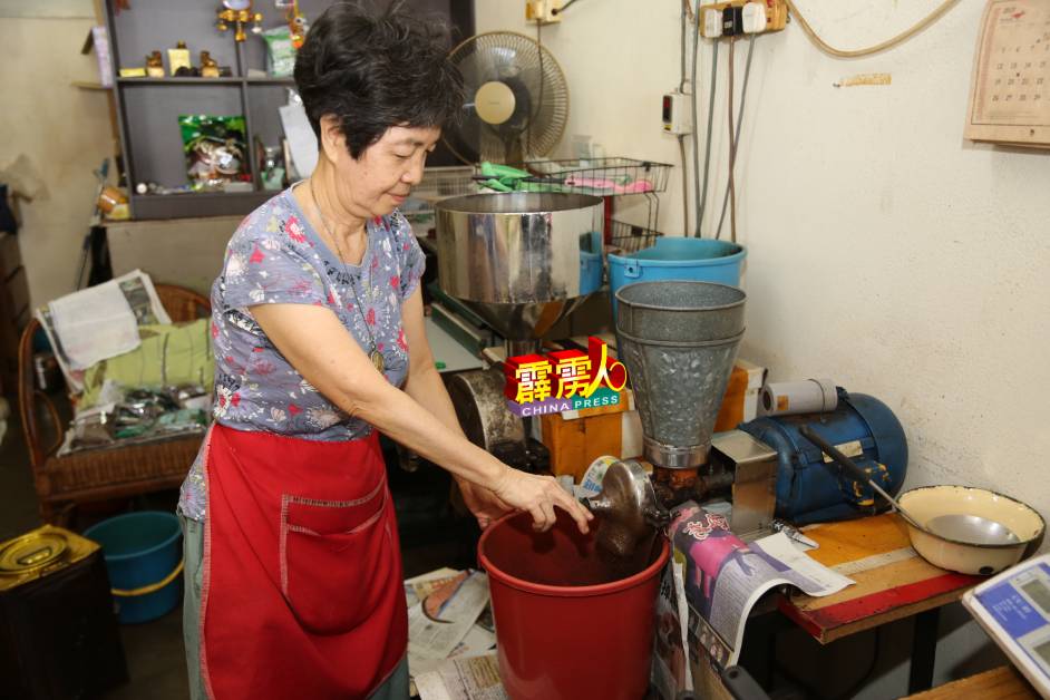 潘玉忙于为顾客所需的咖啡豆磨成咖啡粉。