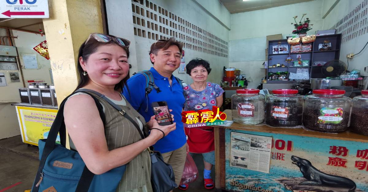 来自香港的梁艳冰（左起）与丈夫高兴地展示在网上寻找潘玉的怡保所售卖的咖啡豆。