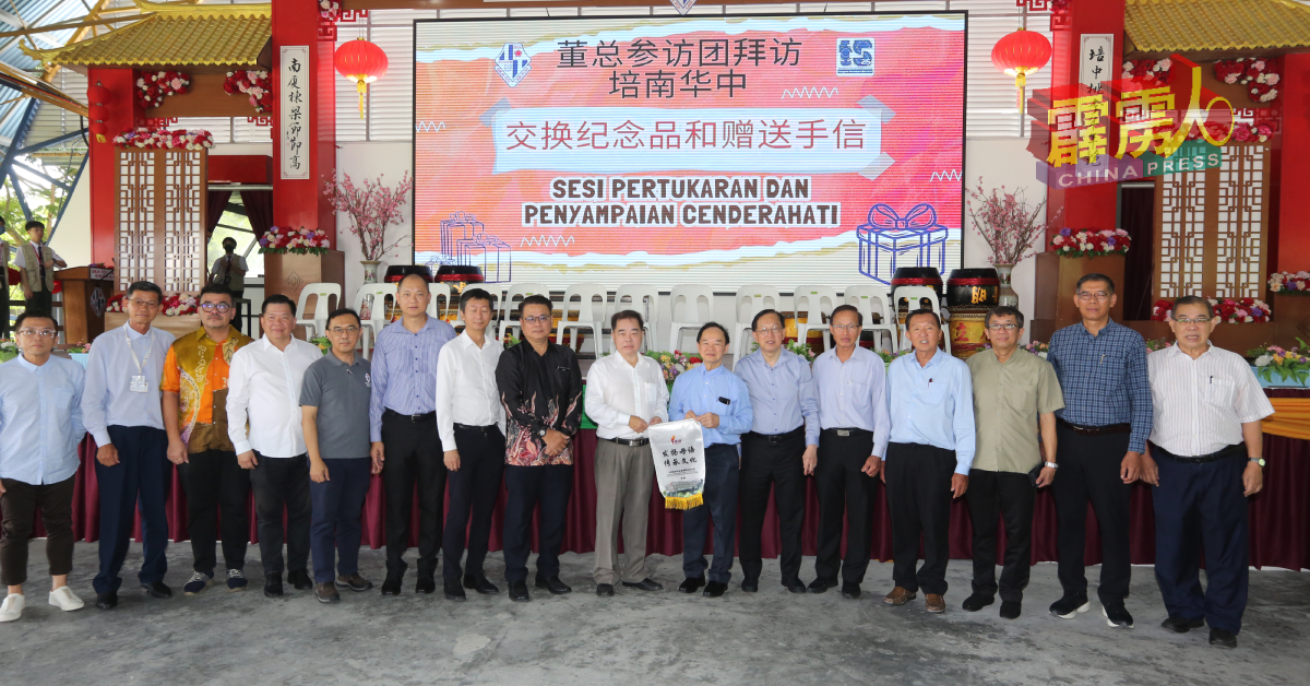 陈大锦（右7起）赠送锦旗给培南华中董事长陈德杰。