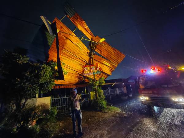 孟加兰顺和花园的一间住宅的屋顶遭狂风刮起后，掉落在相隔两间的住家凉棚上。（李存孝提供）