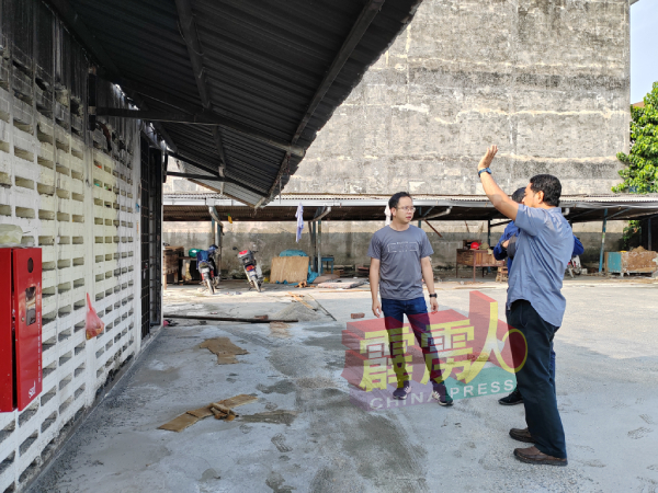 吴锡华（左）在大和园巴刹处，向有关当局的工作人员，了解最新的进展。