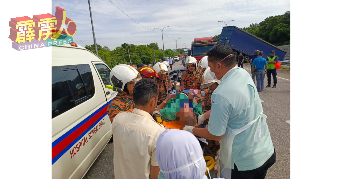 消拯员将夹住的华裔轿车司机救出后，由救护车紧急送往医院接受治疗。（消拯局）