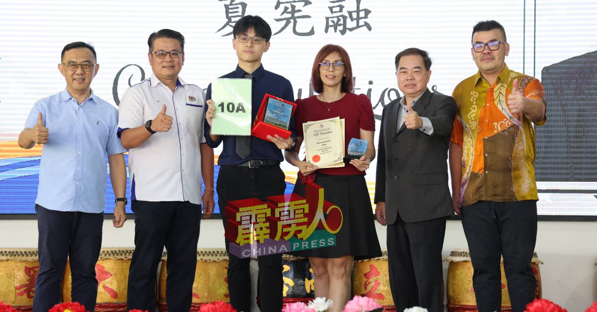 夏宪融（左3起）在母亲刘艳玲陪同下，接过校方颁发“2023年大马教育文凭成绩最佳奖”。左起为郑国强丶胡荣华丶陈德杰及黄罗伦。