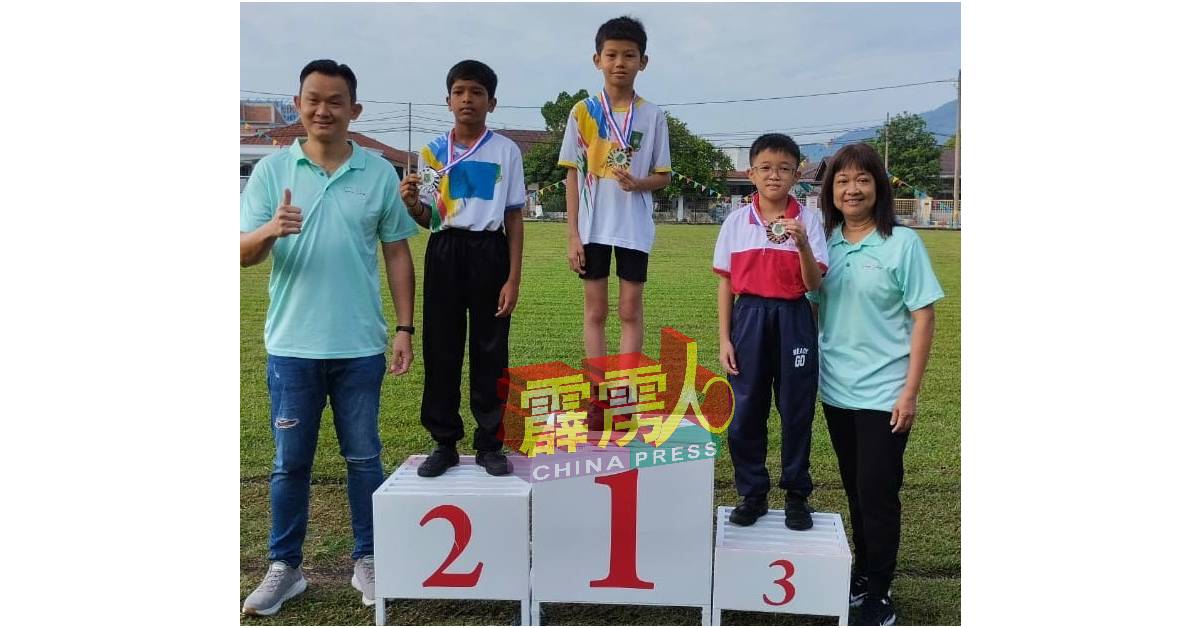 杨健汶（左）受邀主持颁发奖牌予男子组跳远比赛首三名学生後，大赞学生表现。