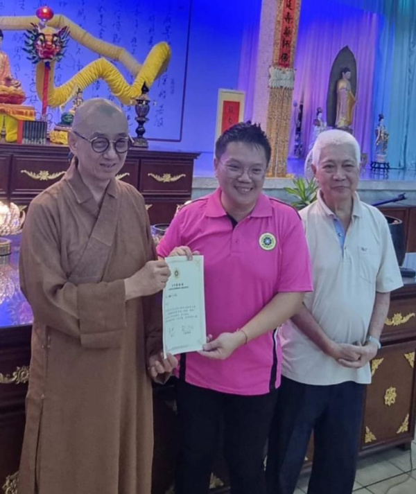 释继程法师（左）颁发委任书给新会长刘培顺，右是黄增金。