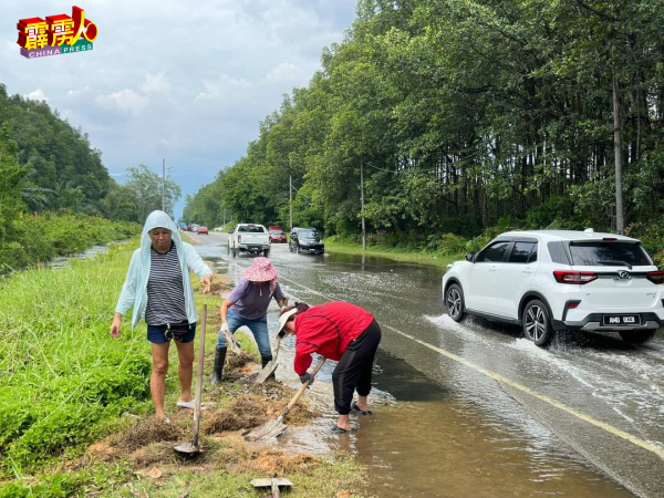 村民在大路最近一次淹水时，动员挥锄挖掘渠道以疏散积水。