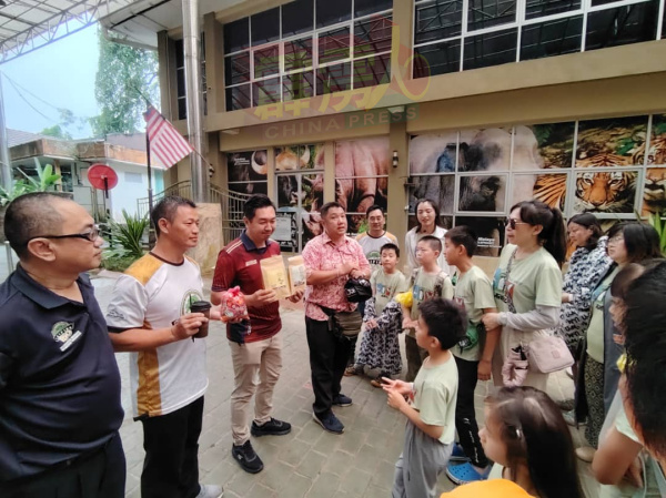 王星元(左3)向中国游客介绍太平的土产,包括香饼和特色饮料“虎咬狮”等。