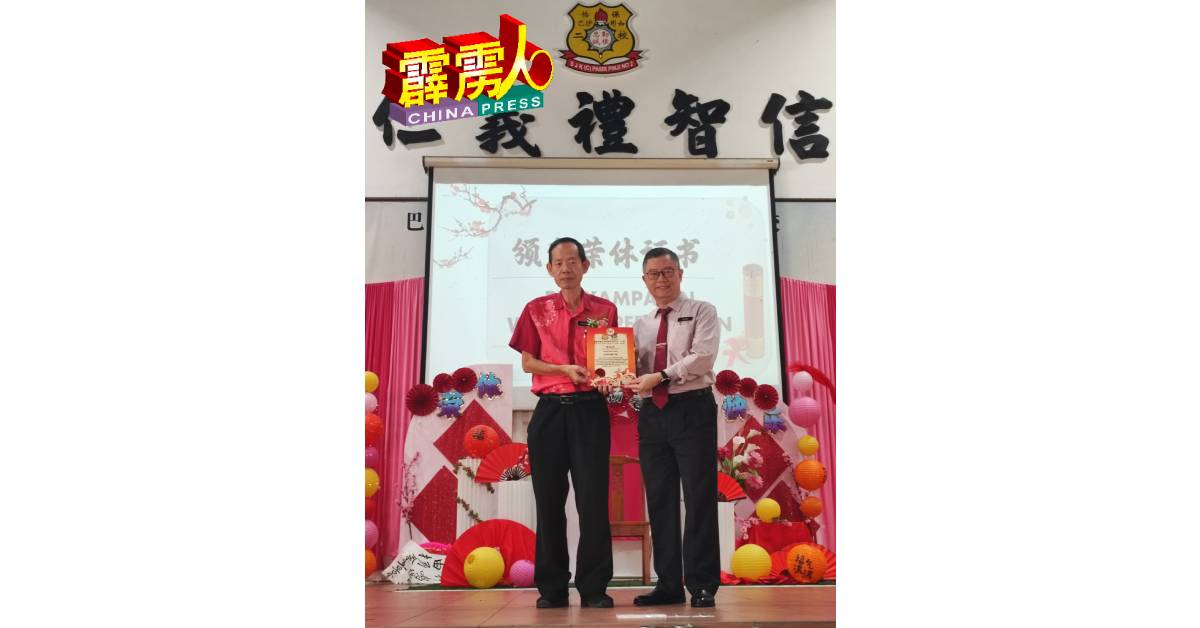 陈绍源校长（右）代表教育局颁发荣休证书给锺鸣扬老师。