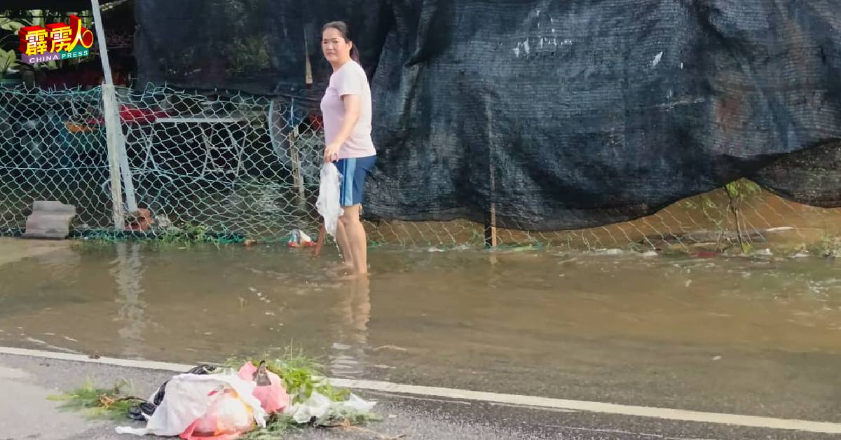 潮水开始消退，女屋主忙着清理屋前垃圾。