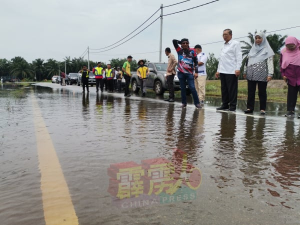 尼查一行人巡视被水淹没的峇眼色海来往司南马的路段。