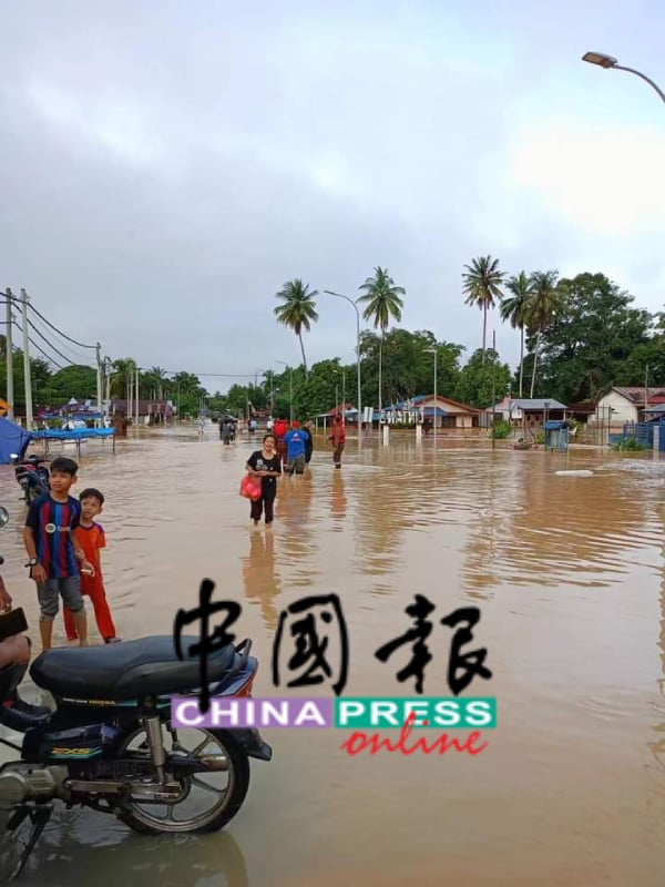 连登镇上马路变河流，灾民涉水而过。