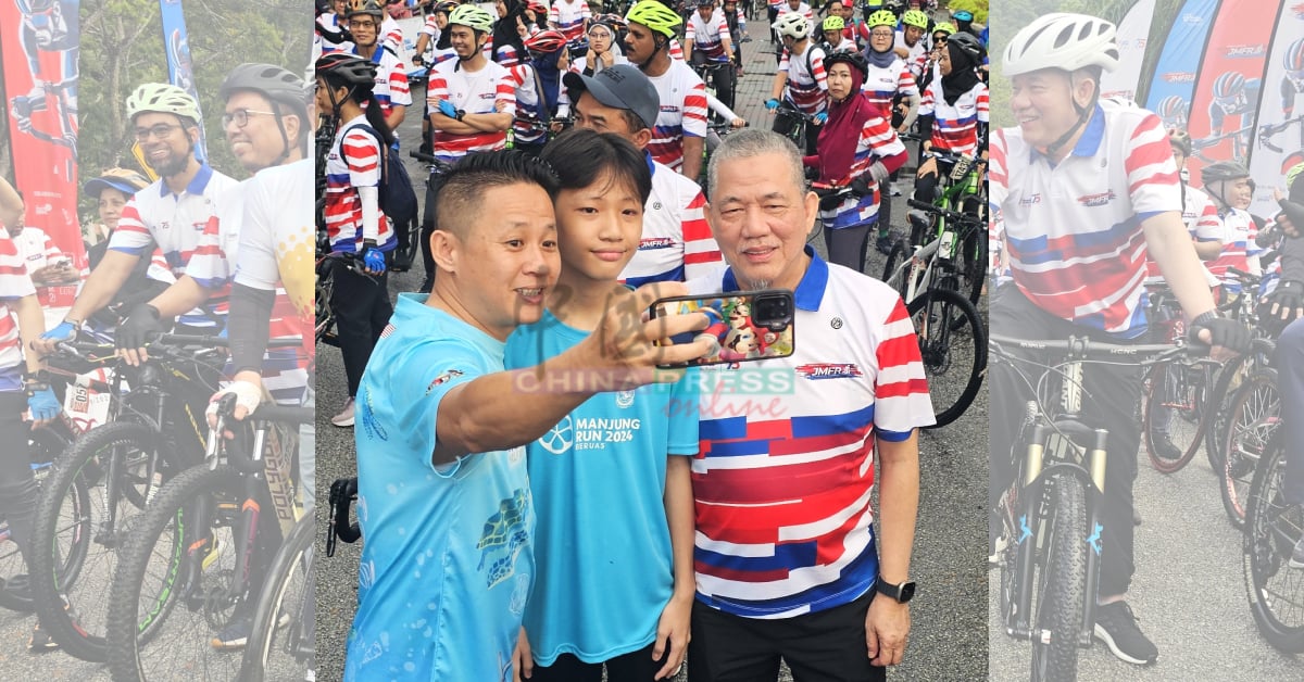 法迪拉尤索夫（右）魅力无法挡，吸引许多民众包括曼绒市议员陈方辉（左）要求合影。