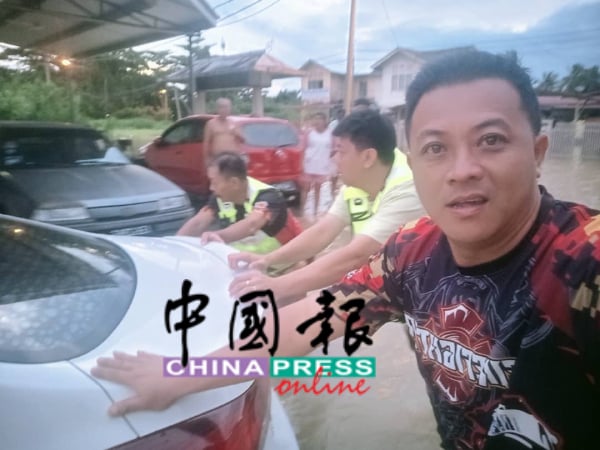 志愿消防队员协助把抛锚汽车移走，避免阻碍交通，前者为陈喜麟。