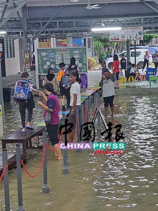 董事部在校方的协助下，利用桌椅和板块，排列筑起临时“板桥”引领学生进入课室，以策安全。