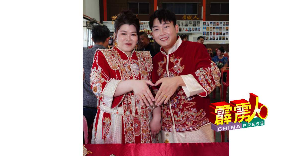 陳瀚霖（右）與江嘉頤特地在網上精心選購龍鳳掛作為結婚禮服，小倆口也在儀式上比愛心。